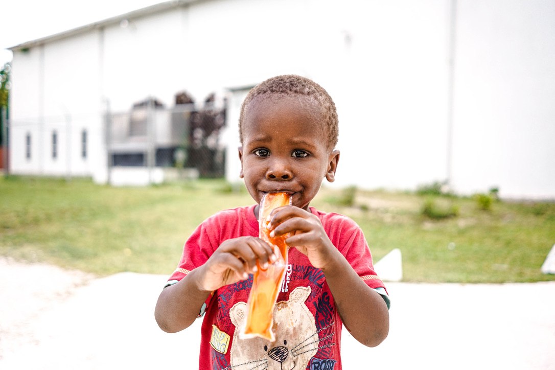 A young boy enjoying a snack outside